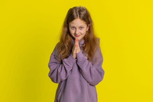 Sneaky cunning preteen child girl kid with tricky face gesticulating and scheming evil plan, thinking over devious villain idea, cheats, jokes, pranks. Teenager funny children on yellow background