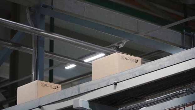 Automation - Cardboard boxes on conveyor belt in factory. Clip. Boxes moving on the conveyor at the factory.