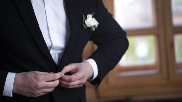 Man buttoning on a black jacket. Wedding details - elegant groom dressed wedding tuxedo costume is waiting for the bride. businessman buttoning jacket, getting dressed. Groom buttons jacket HD