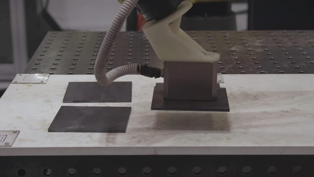Robotic hand machine tool at industrial manufacture factory. Robotic arm uses magnet to transport metal sheets. Industry, Robot concept .The robot arm is working smartly in the production department, the future factory