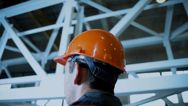 Close up of white workers helmets at construction, view from the back with space. Back view of professional constructor workers. Building processes. Leader part.
