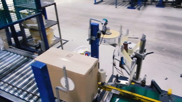 Cardboard boxes on conveyor belt in factory. Clip. Production line on which the boxes move in a spiral.