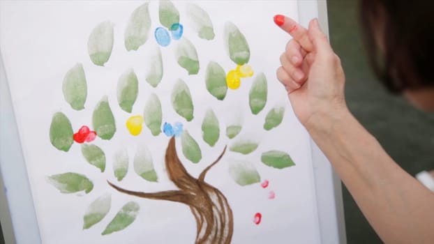 Hands doing Fingerpainting with various colors. Woman's hand draws paint with finger HD