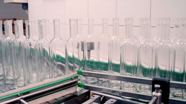 Complex for the production of glass bottles and drinks. Clip. Mechanical machine in a factory with the manufacture of glass containers and liquids