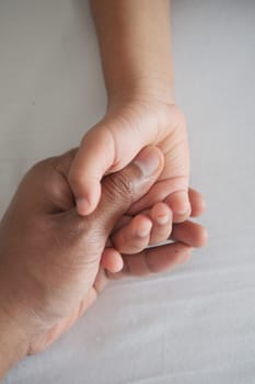 father holding hand of baby child, close up
