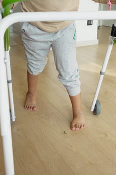 child with walking frame and knee orthosis at home .