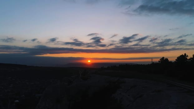 Top view of red sunset with dark mountains. Shot. Amazing colorful time of day. Fiery sun setting over top of hill take away behind itself day.