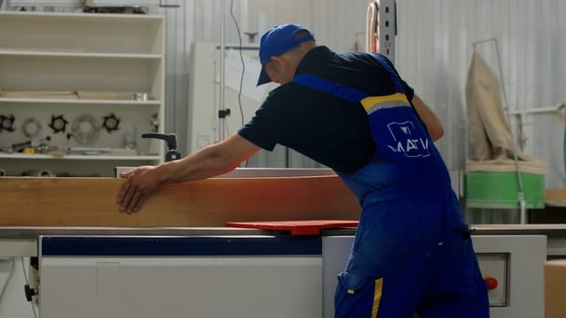 Delhi, India - April 29, 2023: Manufacture of furniture on a joiner's machine. Creative. A special factory with workers in special clothes who process the coatings of the boards. High quality 4k footage