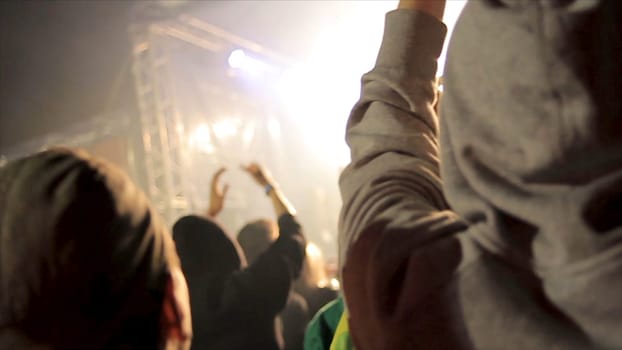 Back view of crowd of people at the concert. Silhouettes of concert crowd in front of bright stage lights. Cheering crowd at a rock concert HD