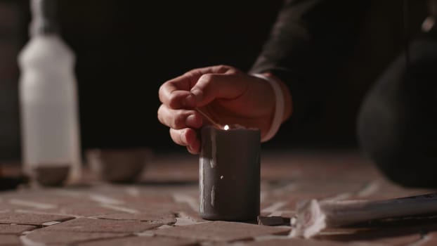 Lighting candle for ceremony. Stock. Man was lighting candle on ground for ceremony. Man with candle at satanic rite.