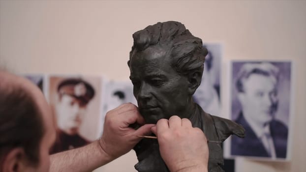 Sculptor created a figure of a man. Clip. Man creates his own hands the bust of a man. Concept art.