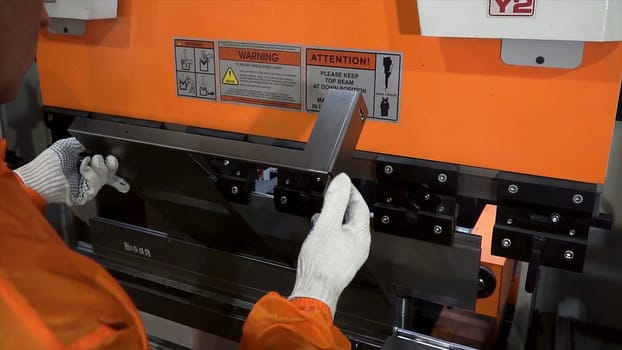 Operator bending metal sheet by sheet bending machine, high precision and high accuracy metal sheet bending machine. Clip. The technician operator use hydraulic bending machine. Metal working concept.