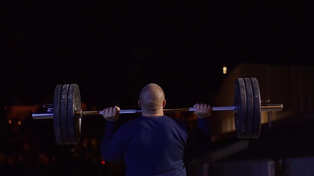 Weightlifter lifts the bar above his head. Strength training with a huge weight. strong crossfit athlete in the middle a heavy snatch lift in a cross-fit box gym 4K