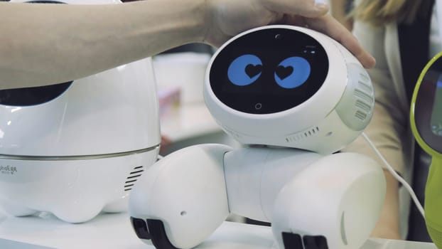 Hand of man touches the robot. Robot is happy with the touch of a human. Technology concept.
