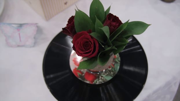 Musical bouquet of roses and record. Beautiful bouquet r of red roses is on gram vinyl. Roses and record. Vintage HD
