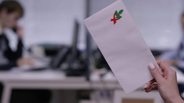 Woman's hand holding closed envelope. Woman's hand holding white envelope.