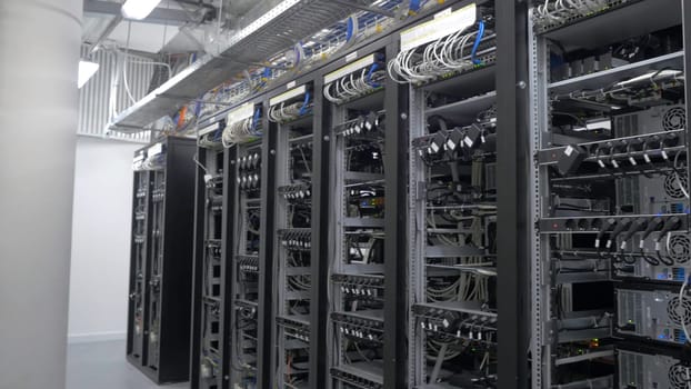Row of bitcoin miners set up on the wired shelfs. Device for mining crypto currency. Mining cryptocurrency. Bitcoin farm. Machines for mining cryptocurrency, bitcoin. Electronic device at day 4K