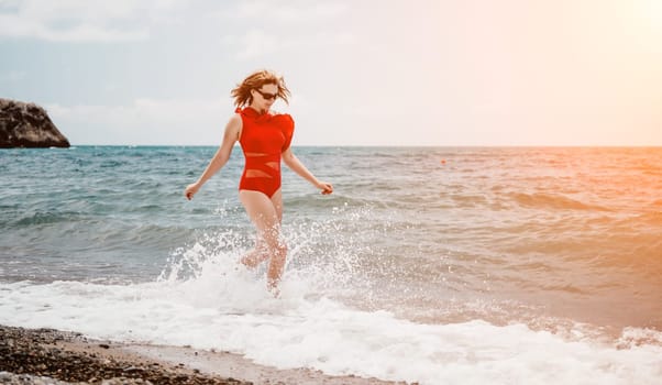 Young happy woman walks carefree on the seaside. Happy lady in red bikini. Portrait beautiful young woman relax smile around beach sea ocean in holiday vacation travel trip.