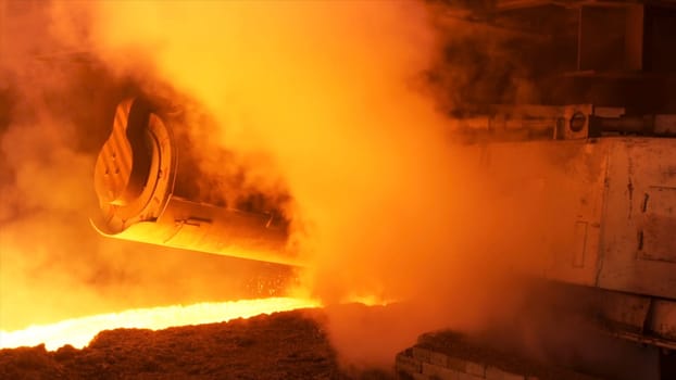 Hot steel production at the steel plant, metallurgy concept. Hot shop with flowing molten steel in the chute.