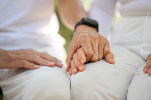 Closeup retired senior couple holding hands symbolizing supporting, empathy and understanding