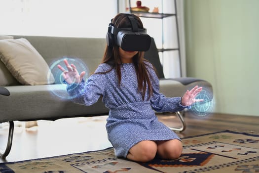 Happy child girl in VR headset touching virtual screen. Concept of futuristic technology