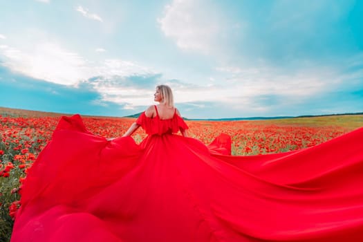 Woman poppy field red dress. Happy woman in a long red dress in a beautiful large poppy field. Blond stands with her back posing on a large field of red poppie