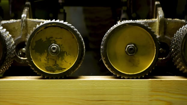 Close up of professional carpenter grinding wooden boards in workshop and lots of sawdust. Manufacturing of wood elements for furniture, timber in factory work processing, industrial line production