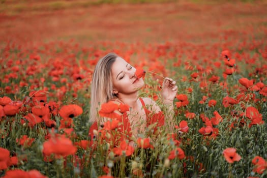 Happy woman in a red dress in a beautiful large poppy field. Blond sits in a red dress, posing on a large field of red poppies.