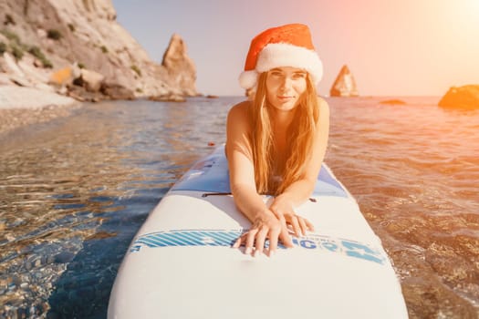 Close up shot of happy young caucasian woman looking at camera and smiling. Cute woman portrait in bikini posing on a volcanic rock high above the sea