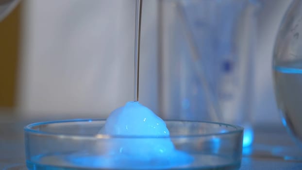 Chemical experiments. The liquid pours from the glass onto the black table, and immediately freezes. immediately freezing liquid 4K