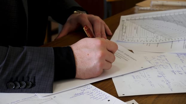 Businessman working with documents in the office. Close up of Young Businessman Using Calculator In Office.
