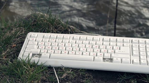 Broken Computer Keyboard. Broken computer keyboard in nature. The concept of technology's adverse impact on the world.