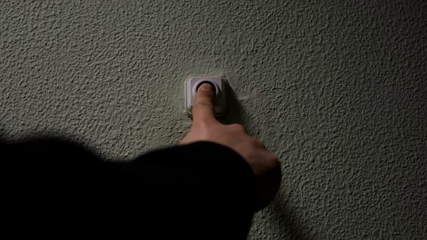 Close up of a male finger pressing a ring bell in the evening. Concept. Impatient man pressing button of a door bell