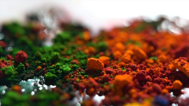 Close up of different color dry inks, art concept. Bright, iridescent background with orange, green, and yellow powder