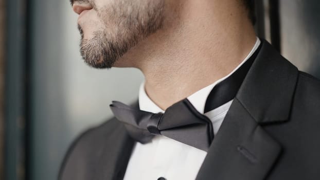 Close-up of man in elegant suit with bow tie. Action. Man in suit for event. Man with elegant suit and bow tie.
