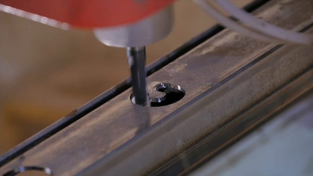 Hole being drilled into metal. Drilling closeup in metal workshop. Employee drill in flat steel plate with bench drill. Industry in slow motion HD