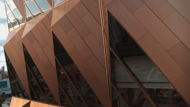 Top view of architecture of modern windows of building with reflection. Stock footage. Reflection of sky in windows of modern office building. Stylish architecture of modern building with reflection and blue sky.