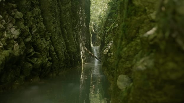 Stunning natural background with green narrow gorge between mountains. Creative. Green river in mountains on a summer day hidden in shadow