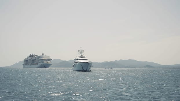 Luxury yacht cruising out at sea. Action. Aerial view of luxury yacht and cruise ship pm rippling water surface
