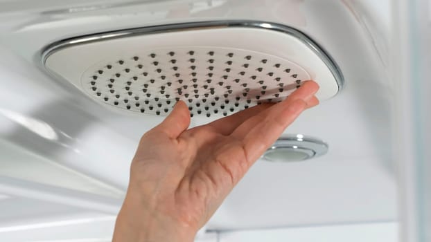 Woman holds hand in the shower close up. Shower cabin. Sliding mechanism of a shower cabin. Shower cabin, stall 4K