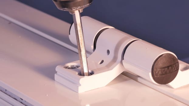 Installation Accessories For Plastic Pvc Windows. Screwdrivers or Drill. Male Hands Fasten Window Handle By Electric Screwdriver. Tempered float glass panels. Industry