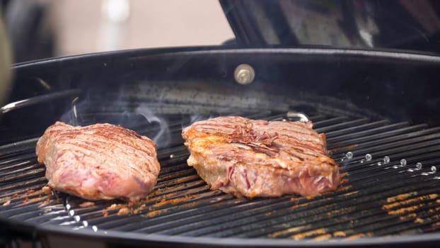Beef steaks on the grill with flames. Cooking steaks on the coals. Concept of eating meat.