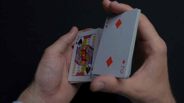 Poker game - shuffling cards. Man's hands shuffing cards. Close up. Man's hands shuffling playing cards. Dealer's hands shuffling cards during a poker game 4K