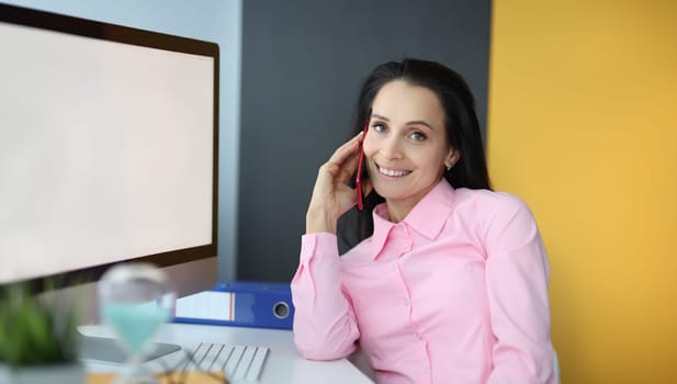 Young woman talking on cell phone in office. Online orders concept