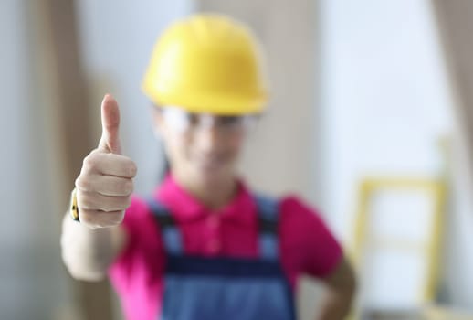 Woman in safety helmet showing thumb up closeup. High quality renovation work concept