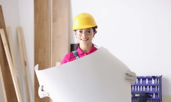 Woman architect holding building construction project in hands. Infrastructure planning concept