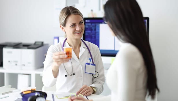 Doctor giving patient bottle of medicine in clinic. Heart disease treatment concept