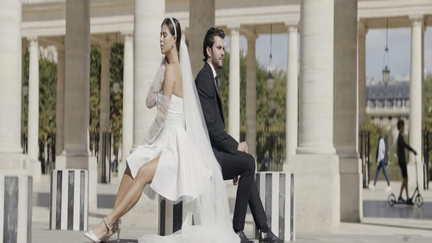 Beautiful date photo shoot. Action.A young girl in a short dress and a man lifting her and sitting in front of the architecture. High quality 4k footage