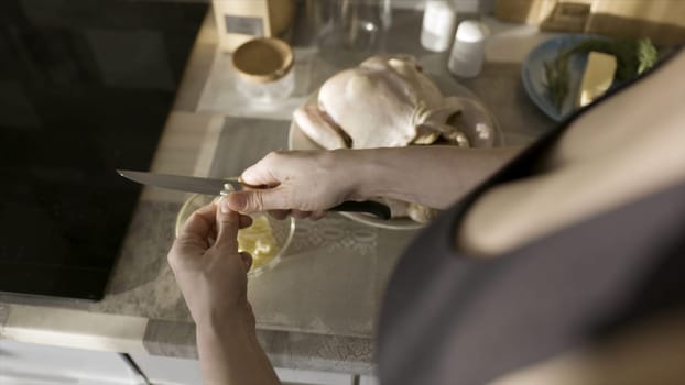 Sexy woman marinating preparing dressing with garlic for chicken baking. Close up of woman cutting garlic with a knife at home in the kitchen, food preparation.