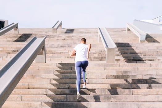 rear view of an unrecognizable sports woman training on stairs, concept of active and healthy lifestyle, copy space for text
